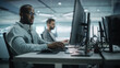 © Gorodenkoff - Diverse Office: Black IT Programmer Working on Desktop Computer. Male Specialist Creating Innovative Software Engineer Developing App, Program, Video Game. Terminal with Coding Language.