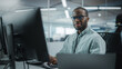 Leinwandbild Motiv Real Office: Professional Black IT Programmer Working on Desktop Computer. Male Website Developer and Software Engineer Developing App, Video Game. Progressive, Innovative and Inspirational Person
