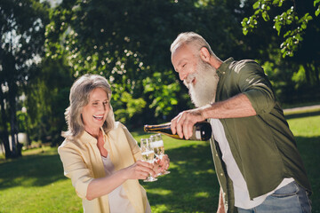 Poster - Photo of impressed old couple drink alcohol wear shirt walk in park outside outdoors