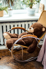 Big brown teddy bear on a wooden rocking chair