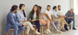 © Studio Romantic - Getting to know the competition. Group of diverse people communicate with each other sitting on chairs in line in the waiting room. Male and female candidates sit on chairs waiting for an interview.
