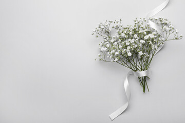 Sticker - Beautiful bouquet of white gypsophila flowers with ribbon on light grey background, top view. Space for text