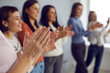 © Studio Romantic - Great success. Close up of male hands applauding on background of blurred colleagues standing in row. People listen and clap their hands at a conference or presentation. Selective focus on hands.