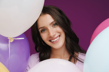 Wall Mural - White brunette woman in smiling while posing with balloons