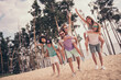 Photo of friendly fooling six young buddies dressed casual outfits walking holding arms piggyback outdoors countryside