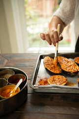 Woman brushing spice to eggplant 