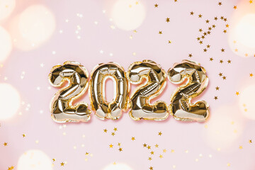 Wall Mural - New year 2022 balloon celebration card. Gold foil balloon number 2022, party decoration, gold confetti on pink background. Flat lay, merry christmas, happy holidays concept.