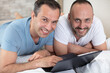 © auremar - gay couple relaxing together  with a laptop computer