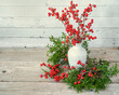 Winterberries in a pottery vase with cedar.