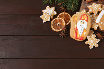 Wall Mural - Tasty gingerbread cookies on wooden table, flat lay with space for text. St. Nicholas Day celebration