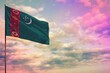 Fluttering Turkmenistan flag mockup with the space for your content on colorful cloudy sky background.