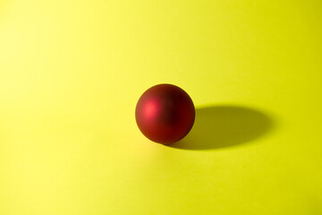 Poster - Red decorative christmas ball on yellow background