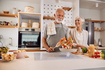 happy senior couple preparing a healthy meal together