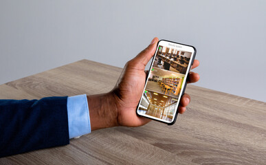 Poster - Hand of caucasian man holding smartphone with view from security cameras at library on screen