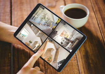 Canvas Print - Hands of caucasian woman holding tablet with view of home from security cameras on screen