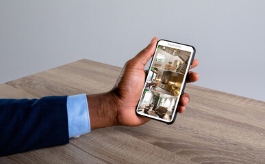 Sticker - Hand of african american man holding smartphone with view of home from security cameras on screen