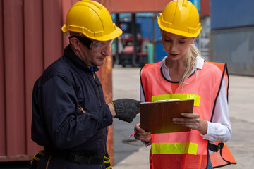 Wall Mural - Industrial worker works with co-worker at overseas shipping container yard . Logistics supply chain management and international goods export concept .