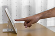 タブレット端末の画面を指さす男の手（日本人、30代)