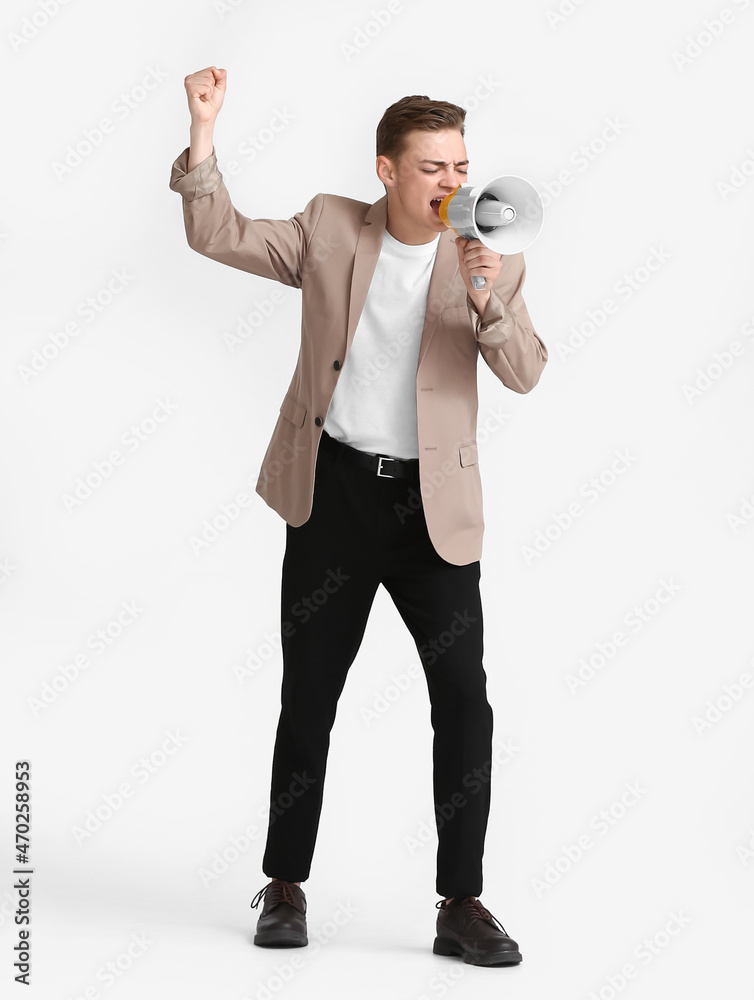Angry teenage boy shouting into megaphone on white background