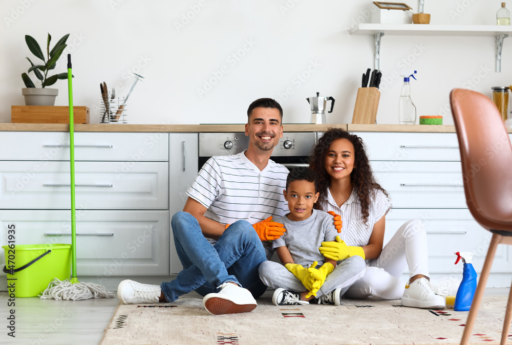 Happy interracial family resting after cleaning kitchen