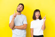 © luismolinero - Young couple isolated on yellow background pointing a great idea and looking up