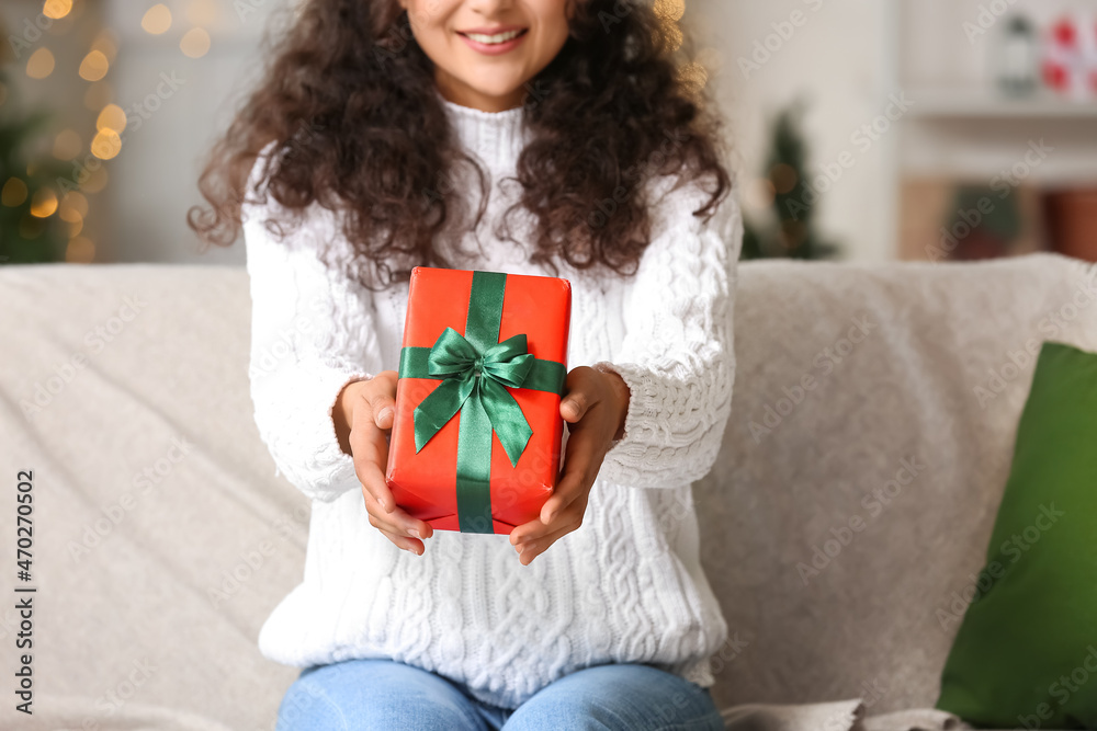 Happy woman with Christmas gift at home