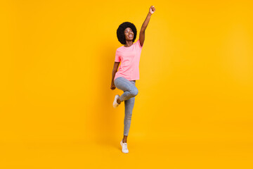 Sticker - Full length photo of impressed young lady look empty space arm up wear pink t-shirt jeans isolated on yellow color background