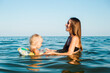© Alex - Child with a circle and mom swim in the sea