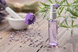 Spray bottle of lavender essential oil. Scented lavender water, serum, flavored water. Lavender flowers on background. Aromatherapy. Natural cosmetic beauty care product. Alternative herbal medicine.