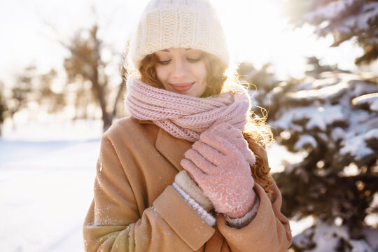 Happy woman in winter style clothes walking in the snowy forest. Nature, holidays, rest, travel concept.