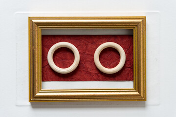 two wooden rings inside a gold frame