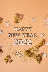 Wall Mural - Festive new year flat lay with numbers 2022 and hard shadows with glasses and shiny decor