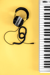 Wall Mural - Musical flat lay background with headphones and musical keys.