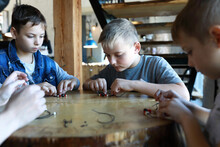Three Children Making Bracelets At Workshop