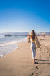 Attractive young woman walking towards Santa Monica beach pier, Los Angeles, California