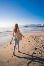 Attractive Young Woman Walking Towards Santa Monica Beach Pier, Los Angeles, California