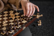 © puhimec - Woman placing chess pieces on a chessboard.