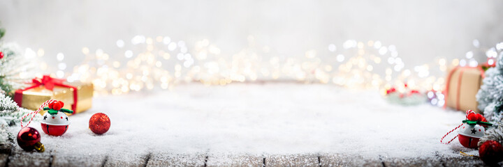 banner with christmas red decorations on snow with fir tree branches and christmas lights. winter de