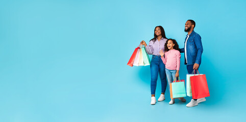 Wall Mural - African American cheerful people holding shopping bags looking aside, panorama