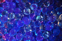 Navy Blue Water Gel Bubbles Balls Background.Transparent Blue Hydrogel Balls. Blue Water Gel Balls With Bokeh. Polymer Gel Silica Gel. Liquid Crystal Ball With Reflection.