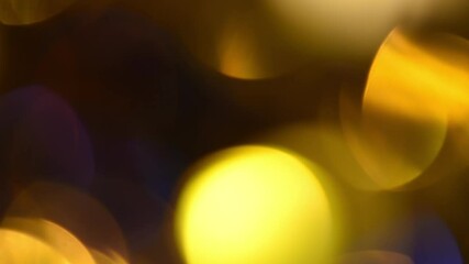 Wall Mural - Bright golden bokeh abstract motion. Beautiful round bokeh of gold and blue colors movement on a black background. Can be used as a background or overlay.