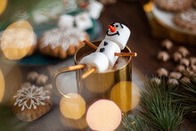 A Marshmallow Snowman Decorated With Icing. Gold Mug With Cocoa And Christmas Decor. Gingerbread In The Form Of Snowflakes.