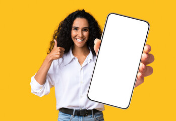 Cute pretty midde-eastern woman showing mobile phone with empty screen
