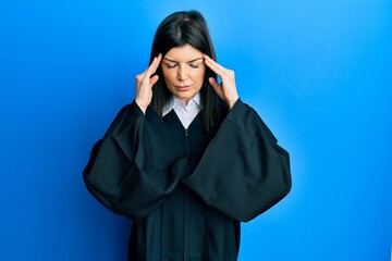 Wall Mural - Young hispanic woman wearing judge uniform with hand on head for pain in head because stress. suffering migraine.