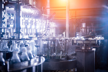 Wall Mural - Automatic filling machine pours water into plastic PET bottles at modern beverage plant.