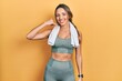 © Krakenimages.com - Beautiful hispanic woman wearing sportswear and towel smiling doing phone gesture with hand and fingers like talking on the telephone. communicating concepts.