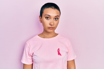 Sticker - Beautiful hispanic woman with short hair wearing pink cancer ribbon on shirt thinking attitude and sober expression looking self confident