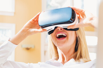 Wall Mural - Happy young woman using a virtual reality headset