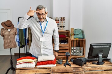 Sticker - Middle age hispanic man working as manager at retail boutique pointing unhappy to pimple on forehead, ugly infection of blackhead. acne and skin problem