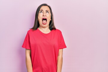 Sticker - Middle age hispanic woman wearing casual clothes angry and mad screaming frustrated and furious, shouting with anger. rage and aggressive concept.